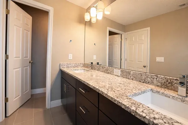a bathroom with a granite countertop sink and a mirror