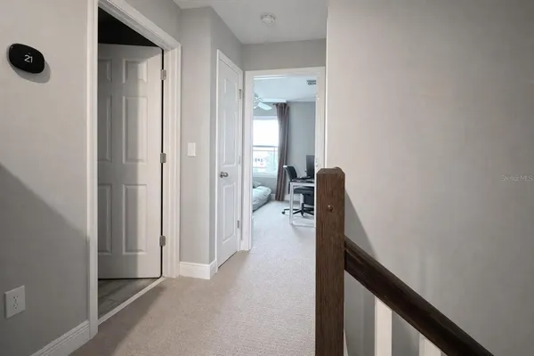a view of a hallway with a closet and a living room view