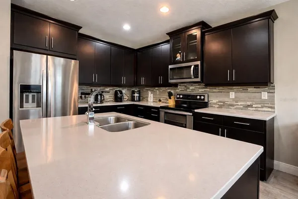 a kitchen with stainless steel appliances wooden cabinets a refrigerator and a stove