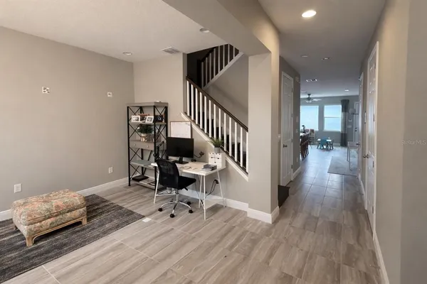 a view of a hallway with wooden floor and stairs