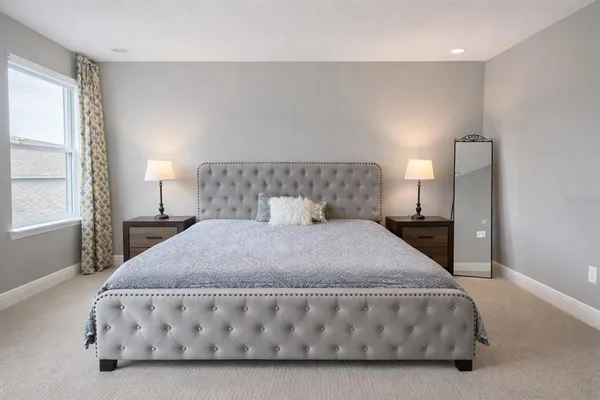 a large bed sitting in a bedroom next to a window