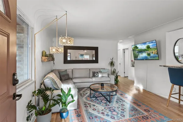 a living room with furniture a chandelier and a flat screen tv