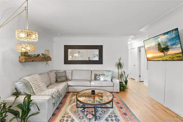 a living room with furniture a rug and a wall painting