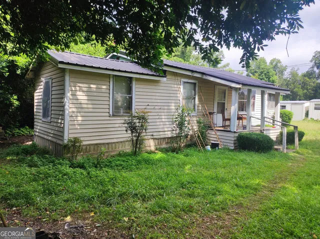 a backyard of a house with table and chairs