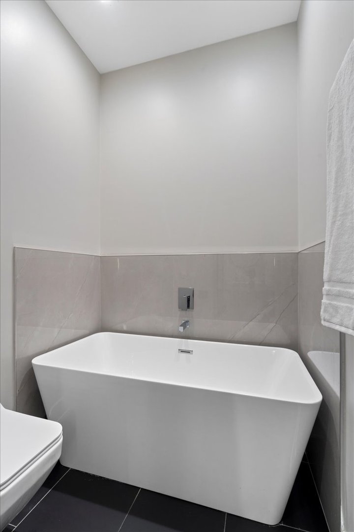 4232 West Belmont Avenue, Unit 2 Chicago, IL 60641 - Photo 20 of 35 a bathroom with a bathtub and toilet