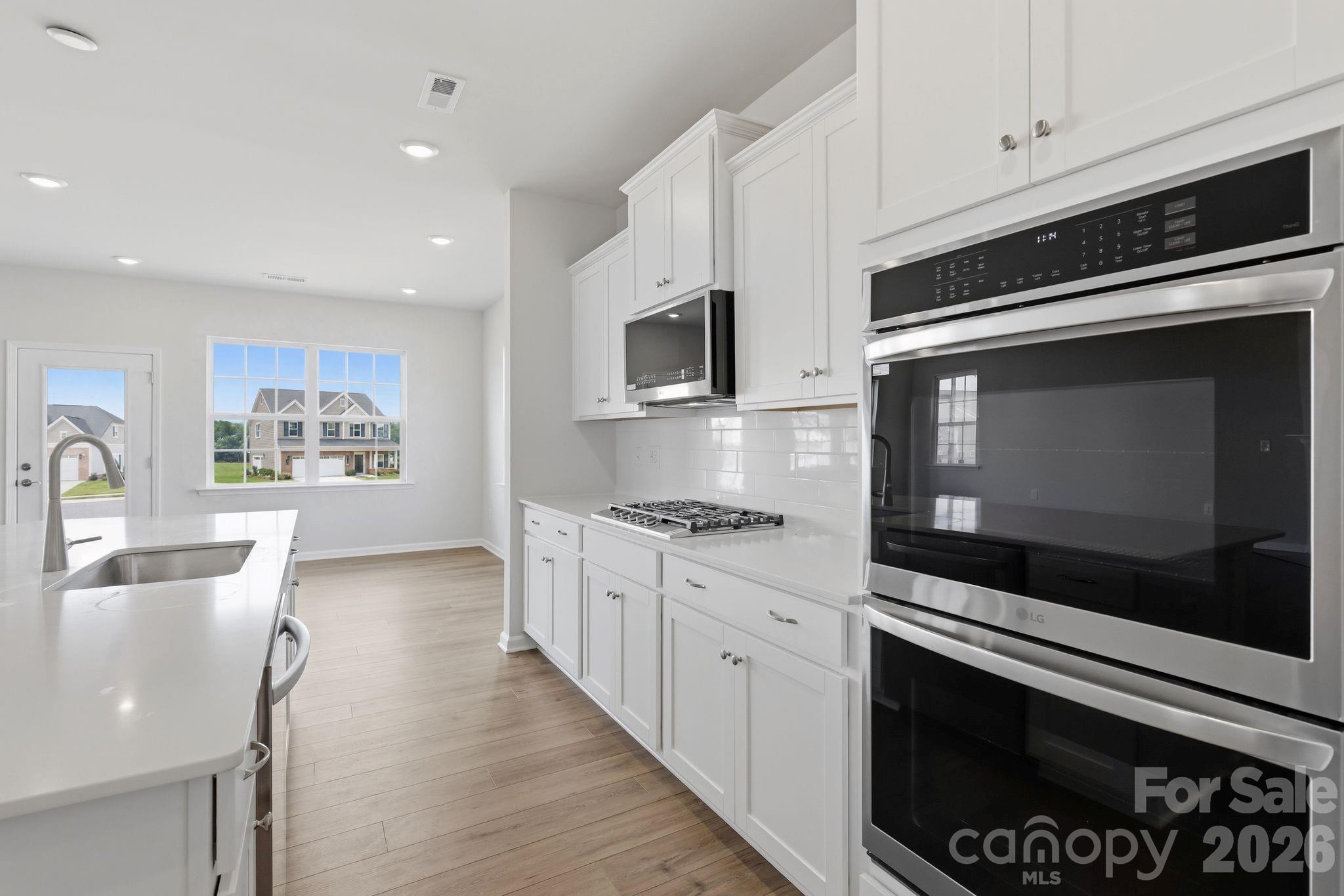 5475 Redbud Road, Unit 57 Lancaster, SC 29720 - Photo 14 of 30 a kitchen with stainless steel appliances white cabinets and stove top oven