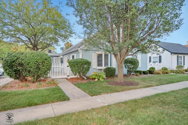 a front view of a house with a yard and trees