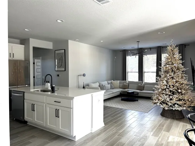 a living room with furniture a flat screen tv and a window