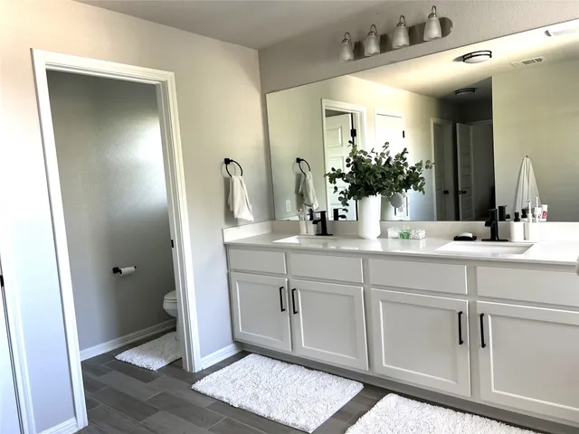 a bathroom with double vanity and a bathtub