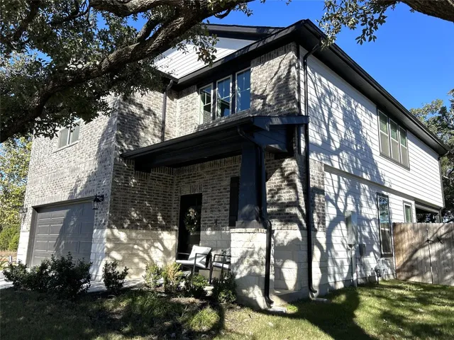 a front view of a house with a garden and trees