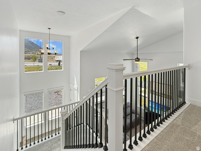 641 Desert Willow Drive Mapleton, UT 84664 - Photo 17 of 41 Corridor with carpet floors, an upstairs landing, a high textured ceiling, and suspended lighting