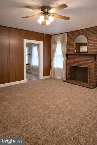 a view of an empty room with a fireplace and a window