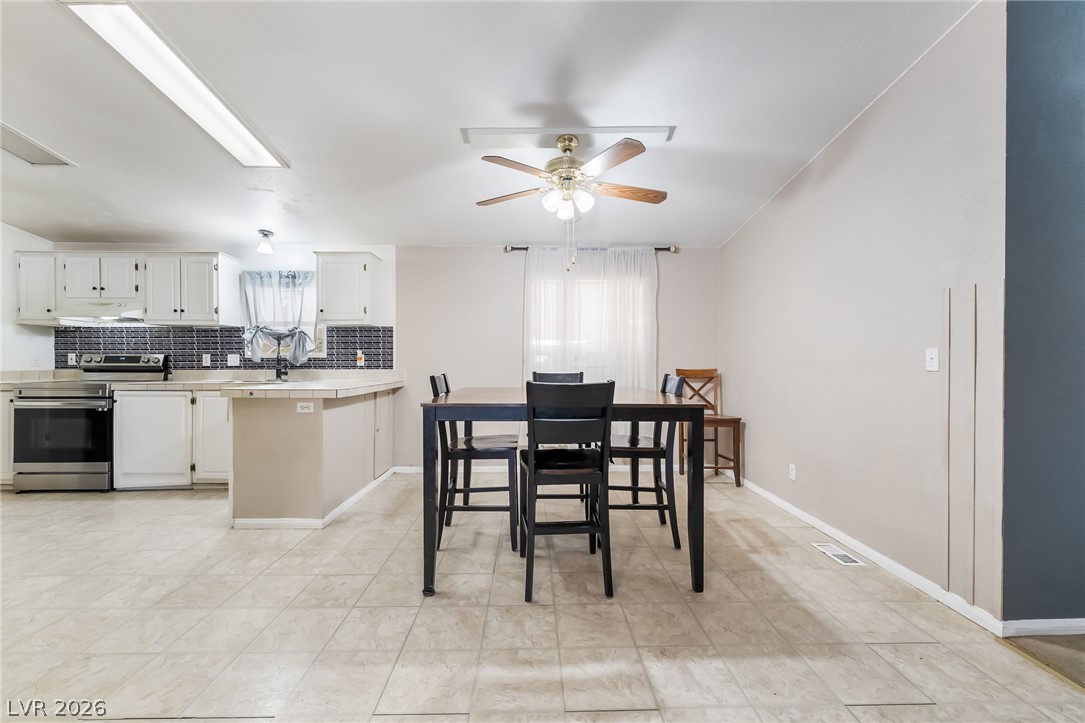 1551 West Wilson Road Pahrump, NV 89048 - Photo 14 of 68 An open dining area flows directly into the kitchen over neutral tile flooring.