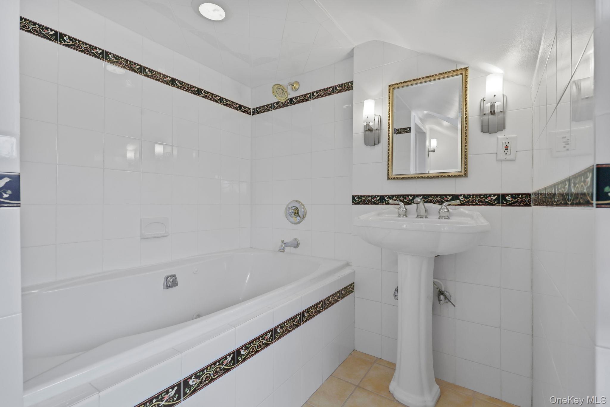 401 Heathcote Road Scarsdale, NY 10583 - Photo 29 of 41 a bathroom with a bathtub and a shower