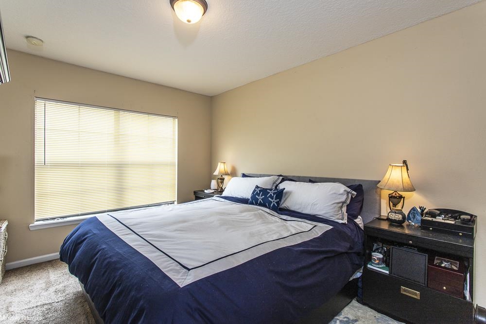 428 Cabernet Place St. Augustine, FL 32084 - Photo 12 of 21 a bedroom with a bed and a lamp next to a window