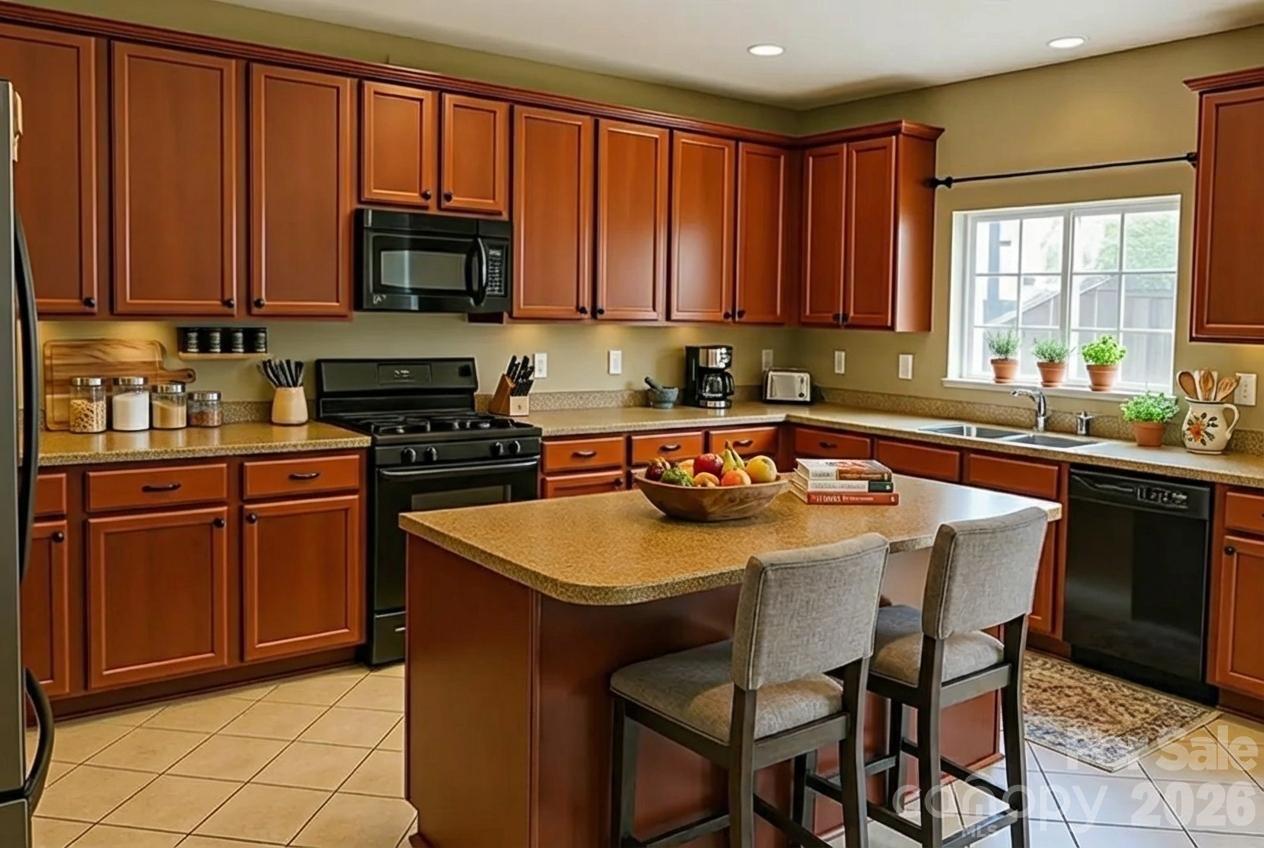6639 Ruth Ferrell Court Charlotte, NC 28269 - Photo 9 of 30 a kitchen with stainless steel appliances granite countertop a sink a stove a microwave cabinets and a dining table with wooden floor