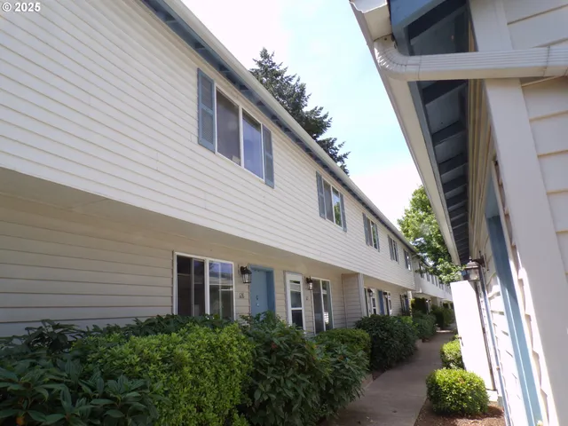 a front view of a house with plants and entryway