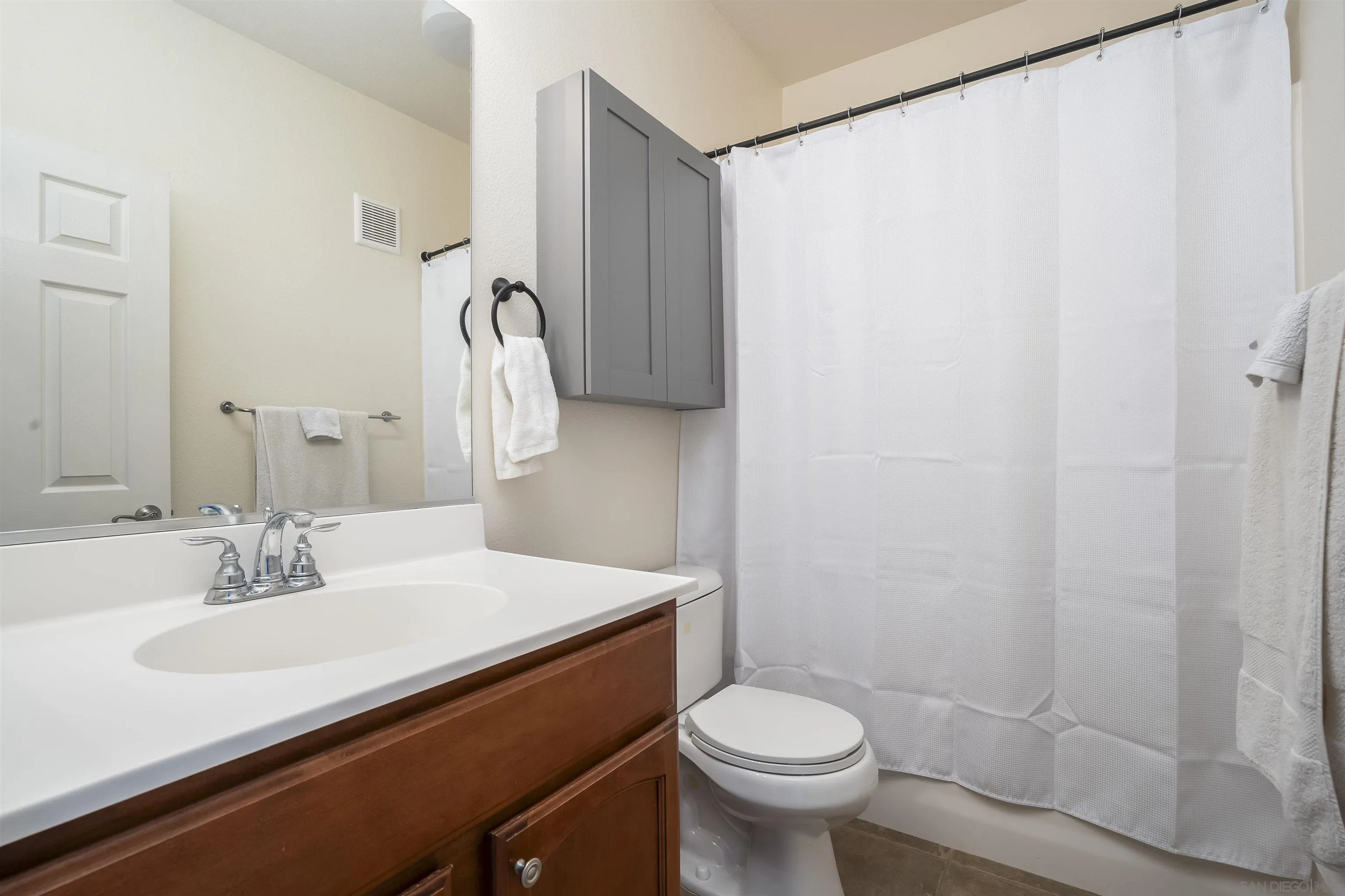 289 Reef Point Way, Unit 3 Oceanside, CA 92058 - Photo 16 of 23 a bathroom with a sink a toilet and shower curtain