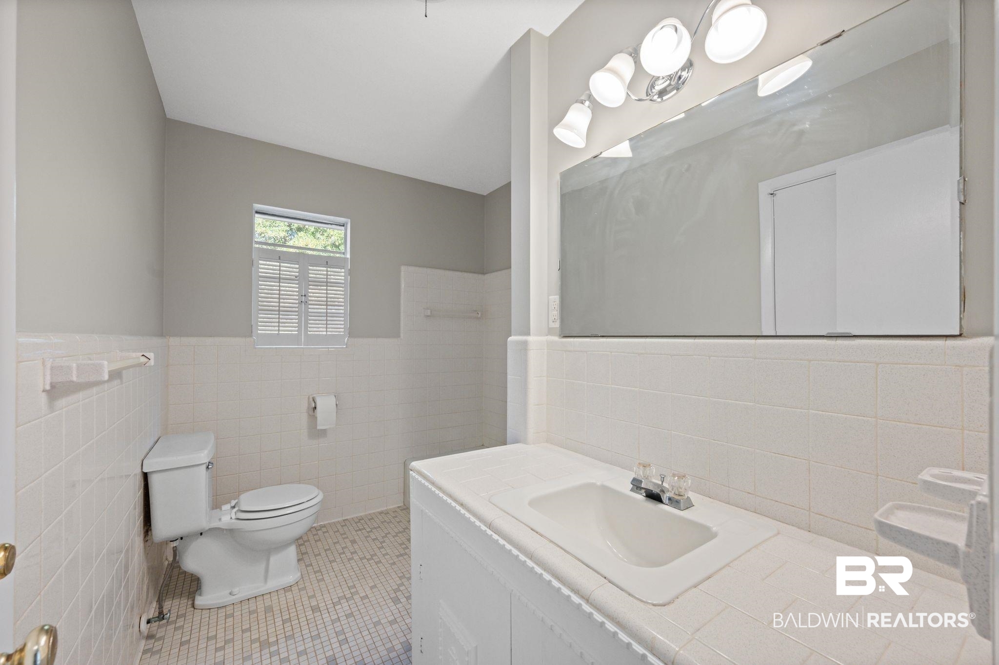 909 Caroline Avenue Daphne, AL 36526 - Photo 25 of 46 Bathroom with tile patterned floors, vanity, tile walls, and toilet