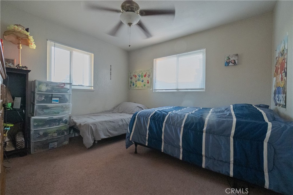 1083 Lorraine Place Rialto, CA 92376 - Photo 16 of 20 a bedroom with a bed and a chandelier