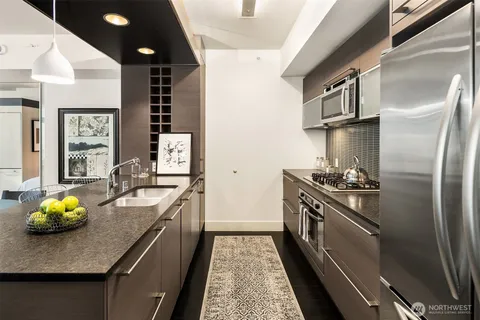 a kitchen with stainless steel appliances granite countertop a sink a stove and a refrigerator