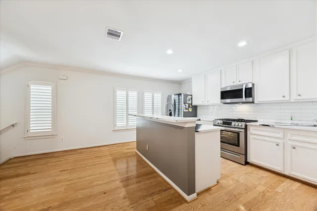 a kitchen with stainless steel appliances granite countertop a stove a sink and a microwave