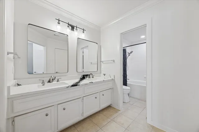 a bathroom with a double vanity sink mirror and toilet