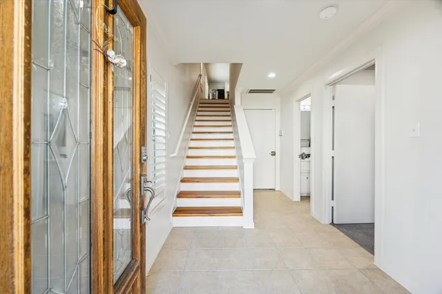a view of a hallway with entryway and stairs