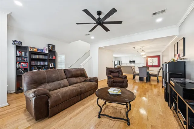a living room with furniture kitchen view and a flat screen tv