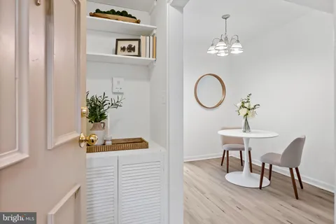 a dining room with furniture a chandelier and wooden floor