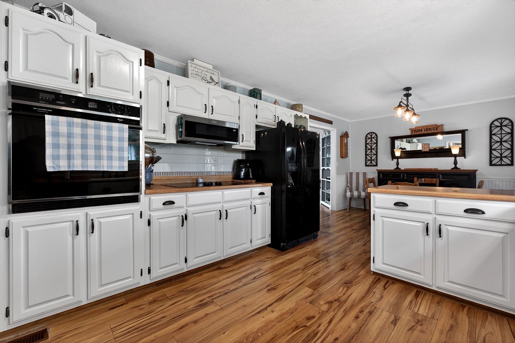 1755 Burgess Falls Road Sparta, TN 38583 - Photo 26 of 56 a kitchen with stainless steel appliances white cabinets a sink a stove a microwave and wooden floors