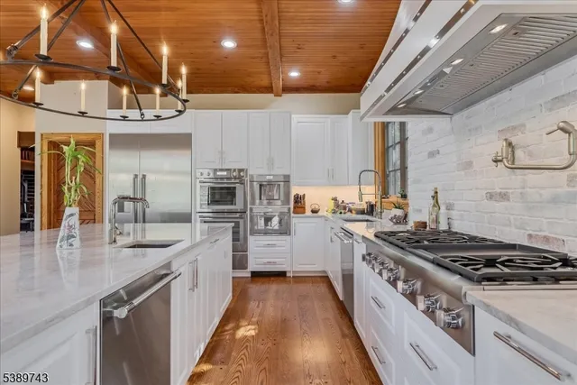 a kitchen with stainless steel appliances a sink stove and cabinets