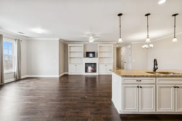 a view of a kitchen with a sink dishwasher a fireplace with wooden floor