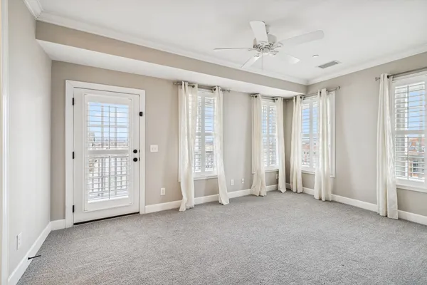 an empty room with windows and closet area