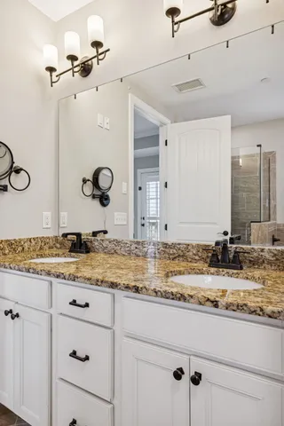 a bathroom with a granite countertop sink mirror and vanity