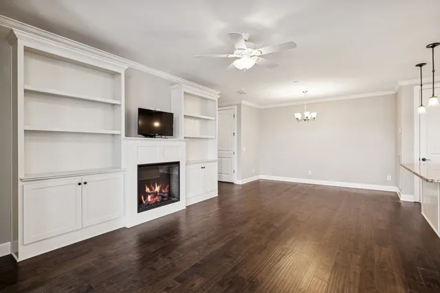 a view of an empty room with wooden floor and fireplace