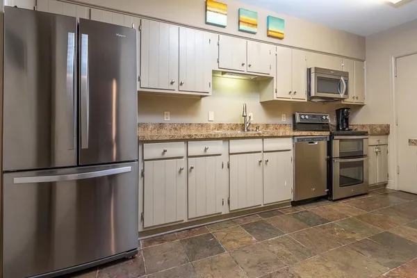 a kitchen with stainless steel appliances granite countertop a refrigerator sink and cabinets