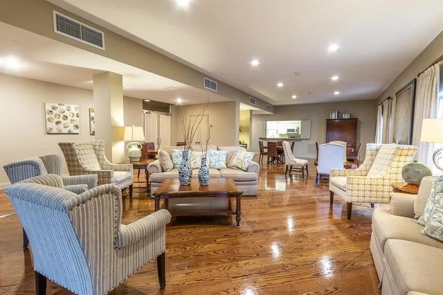 a living room with lots of furniture and view of kitchen