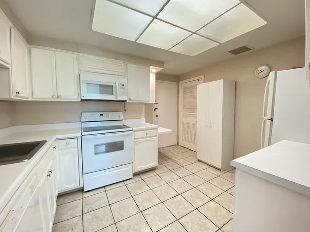 a kitchen with a stove sink and cabinets