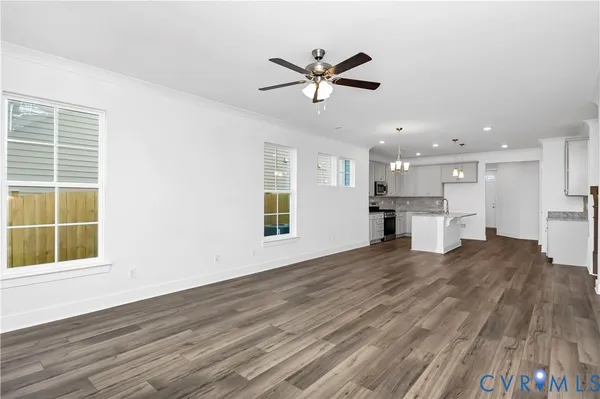 a view of an empty room with a window and wooden floor