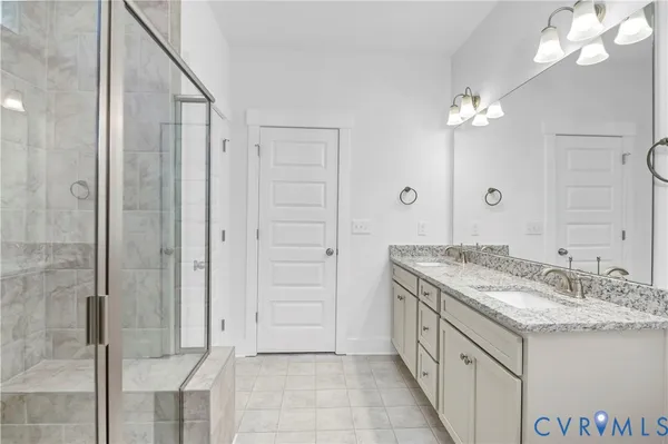 a bathroom with a granite countertop sink a large mirror and a shower
