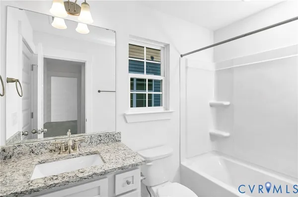 a bathroom with a granite countertop sink a mirror and a bathtub