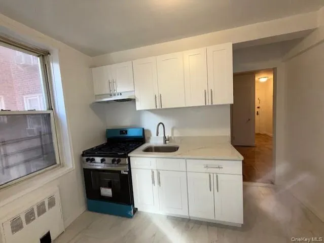 a kitchen with white cabinets and appliances