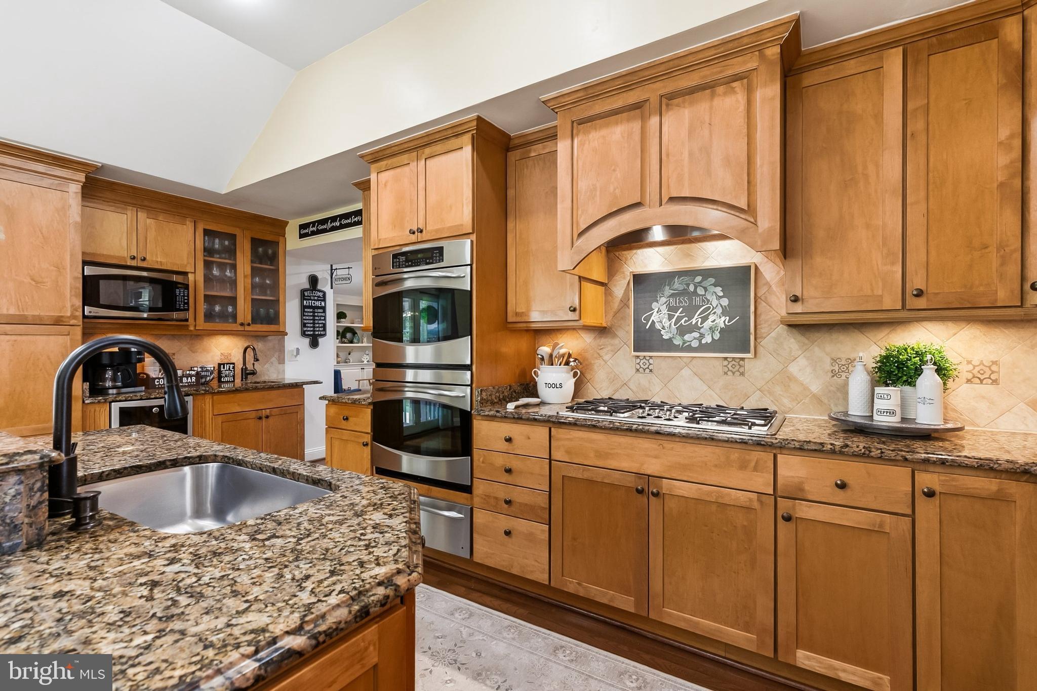 1004 Windmill Lane Silver Spring, MD 20905 - Photo 20 of 60 a kitchen with stainless steel appliances granite countertop a stove a sink and a microwave