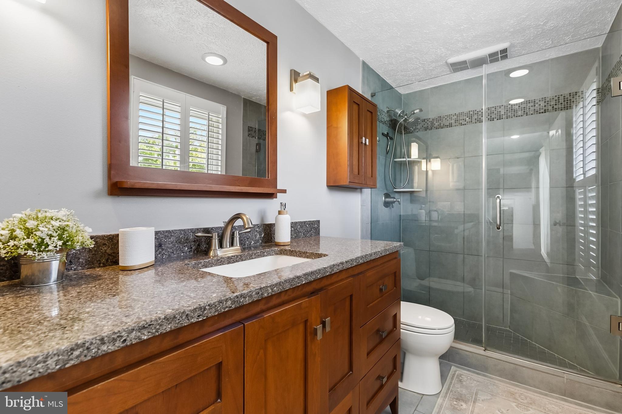 1004 Windmill Lane Silver Spring, MD 20905 - Photo 27 of 60 a bathroom with a granite countertop sink a toilet a mirror and shower