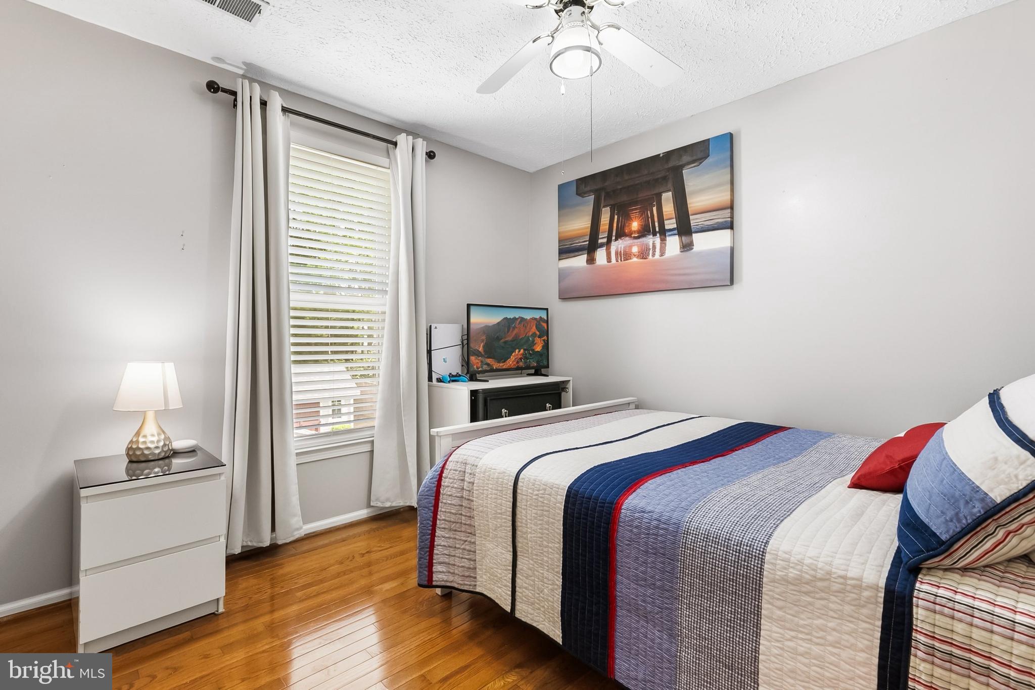 1004 Windmill Lane Silver Spring, MD 20905 - Photo 31 of 60 a bedroom with a bed and a chandelier