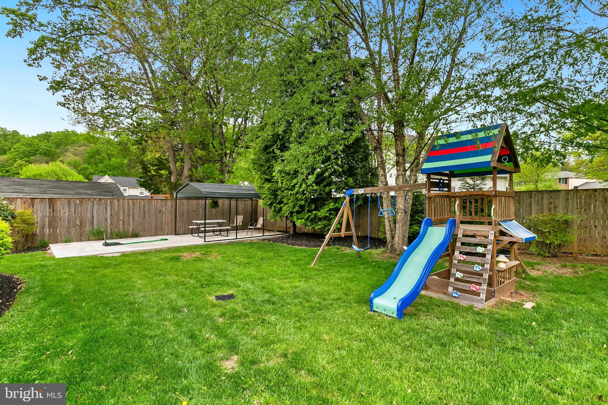 1004 Windmill Lane Silver Spring, MD 20905 - Photo 49 of 60 a view of a backyard with a slide and a slide with wooden fence