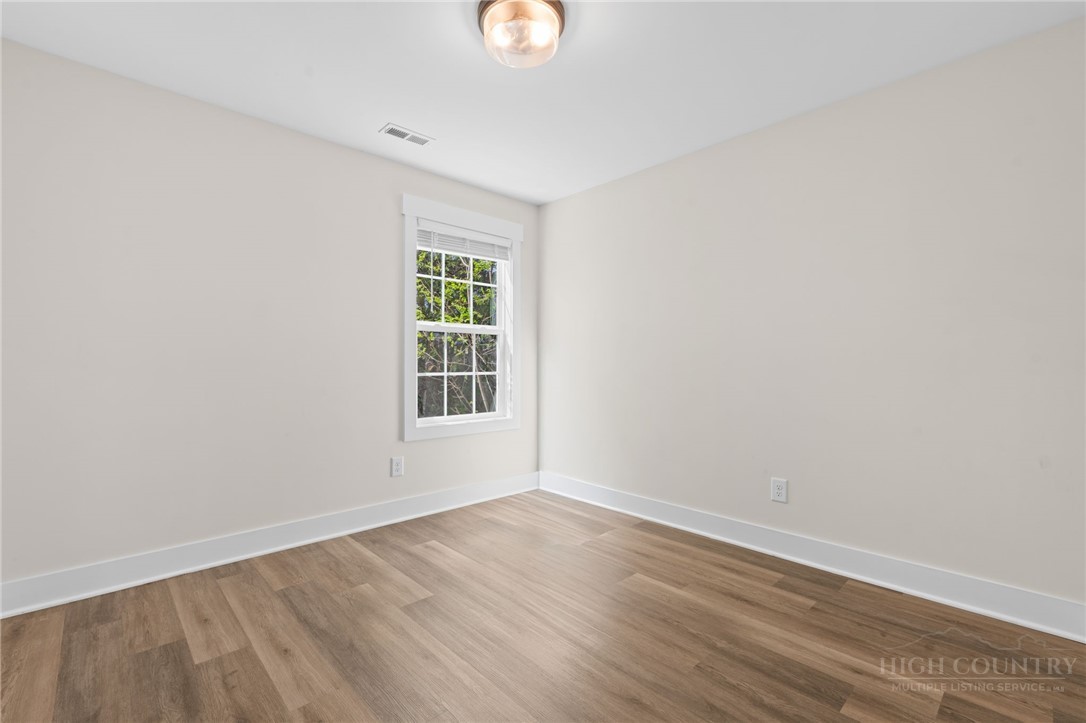 228 Stratford Lane Boone, NC 28607 - Photo 25 of 33 an empty room with wooden floor and windows