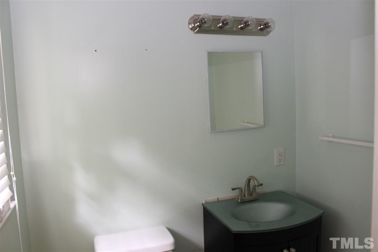2326 Sheffield Road Raleigh, NC 27610 - Photo 14 of 18 a bathroom with a sink a toilet and mirror