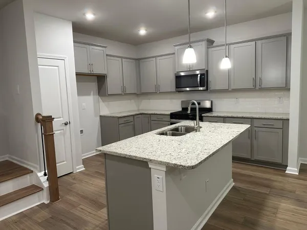 a kitchen with a sink a refrigerator and cabinets